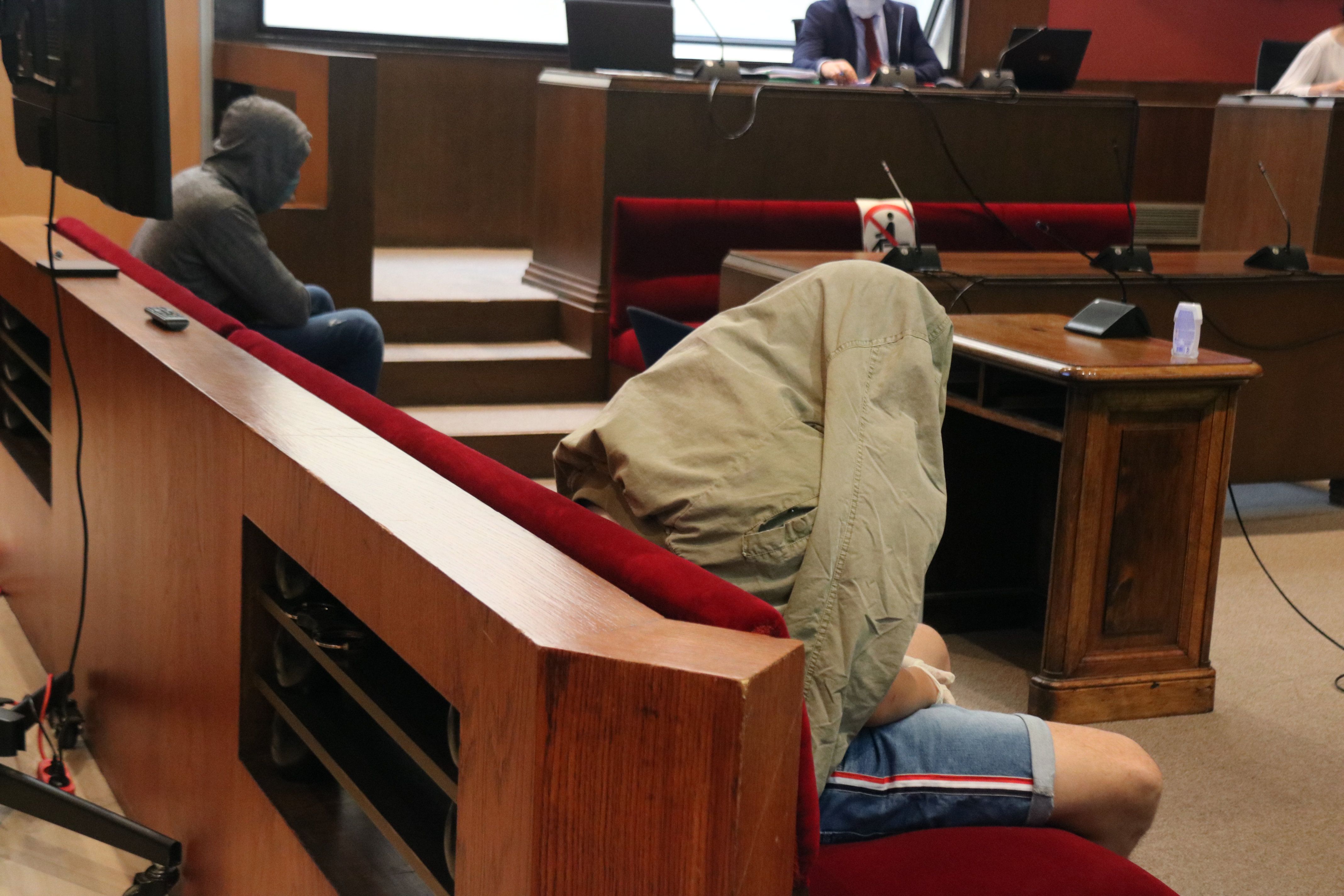 Dos acusados de espaldas durante el juicio por una violación en grupo a una menor en Pineda de Mar. Foto: ACN
