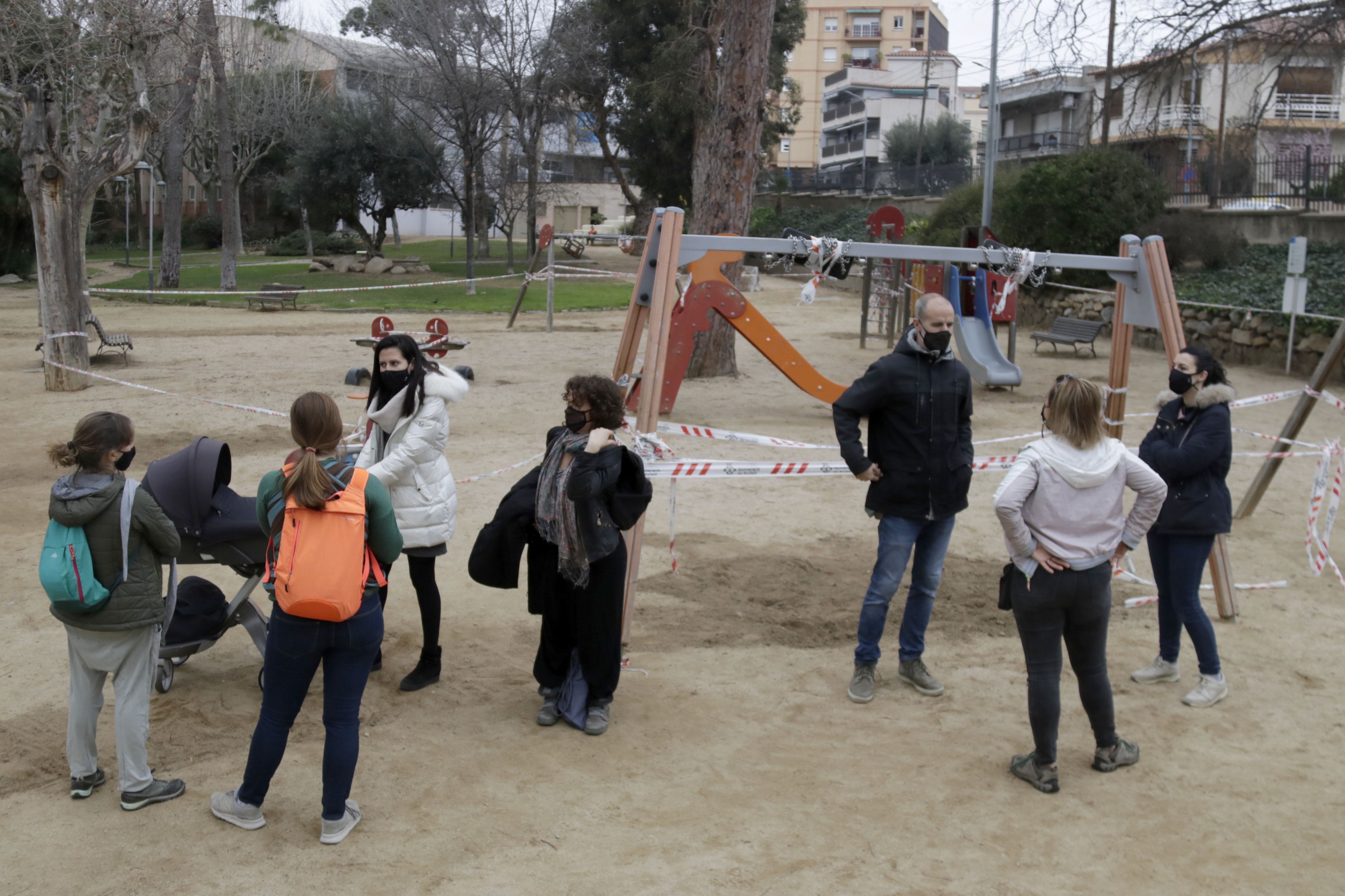 Un grupo de familias ante uno de los parques infantiles cercados en Mataró. Foto: ACN