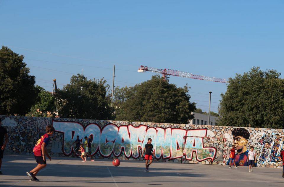 Chicos jugando al fútbol en el parque de Rocafonda con el grafiti de fondo Chicos jugando al fútbol en el parque de Rocafonda con el grafiti de fondo