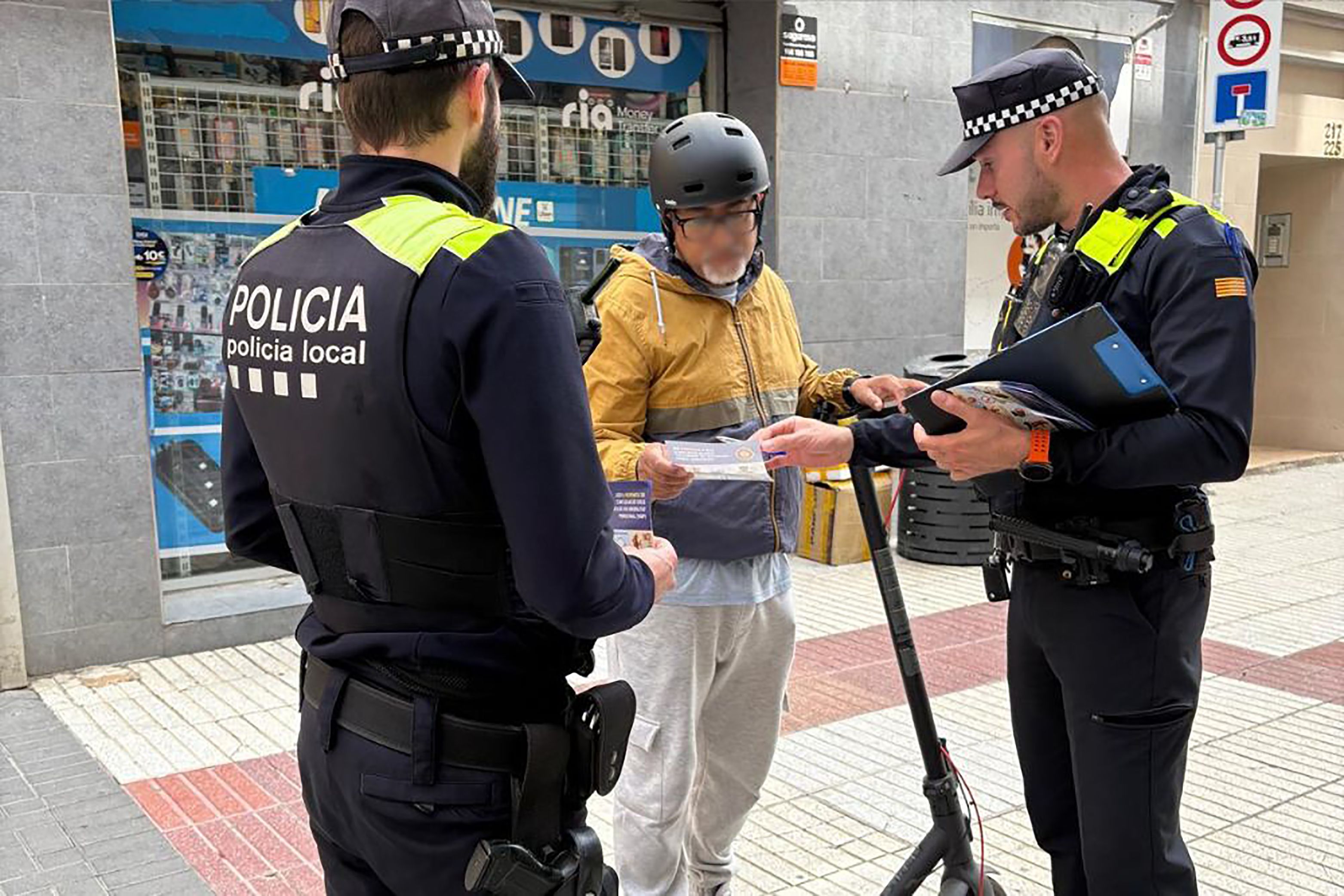 La Policia Local de Calella multant a un conductor de patinet