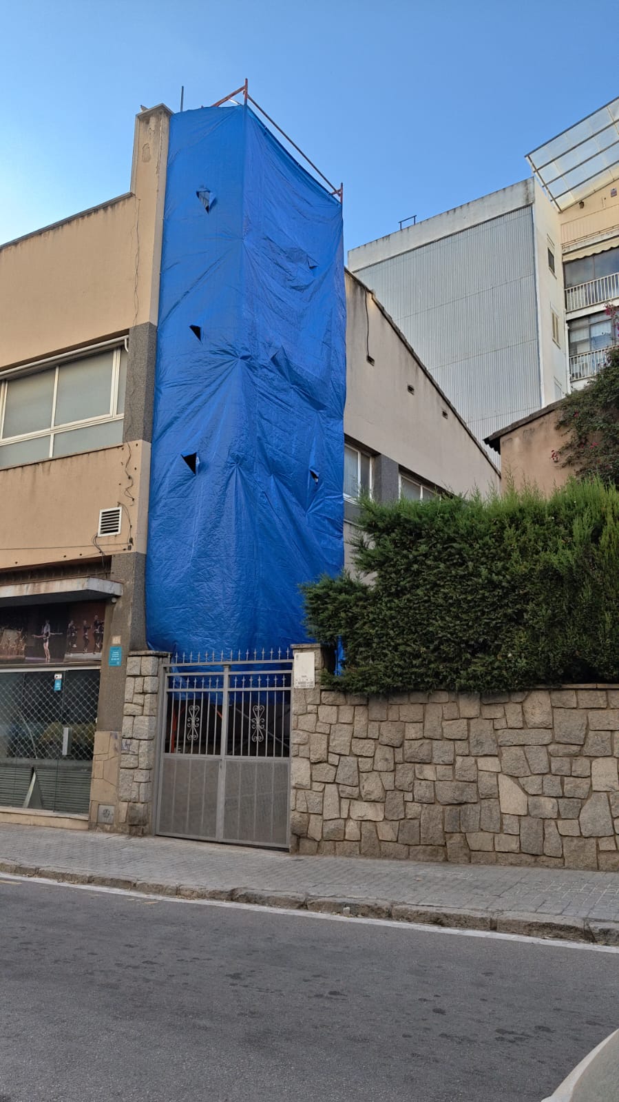 El mural, ja amagat rere una lona d'obra.