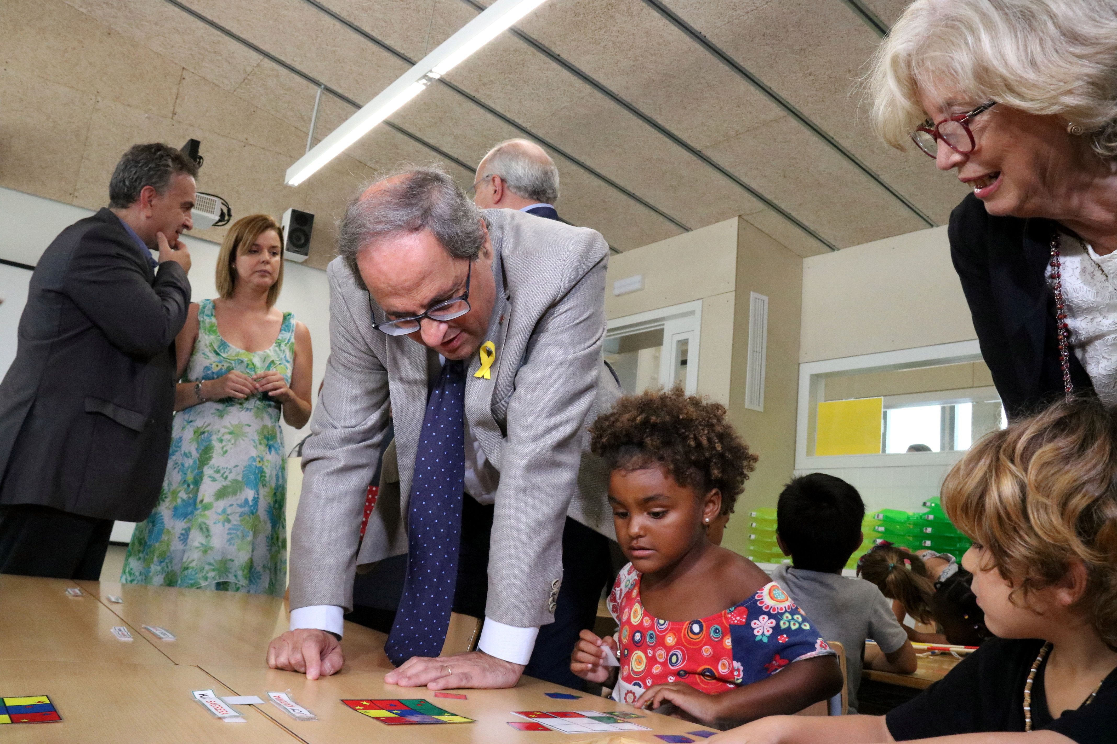 El presidente Quim Tuesta y la ex consejera de Enseñanza, Irene Rigau, hablan con varios niños de la escuela El Faro de Calella