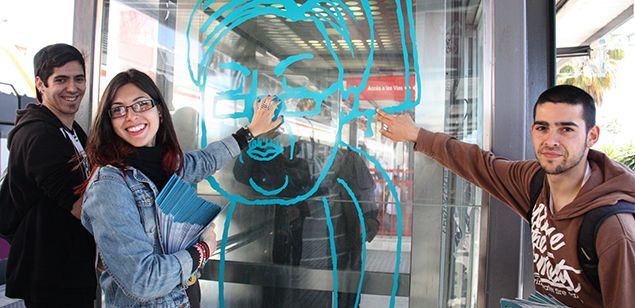 Alumnos del ESAD Pau Gargallo de Badalona con uno de los vinilos del proyecto '22 minutos en tren', a la estación de Mataró
