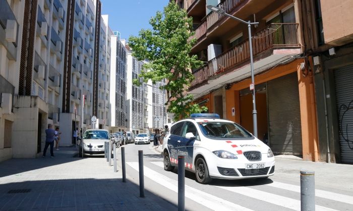 Un vehicle dels Mossos d'Esquadra davant l'edifici del carrer Burriac del barri de Cerdanyola. Foto: ACN