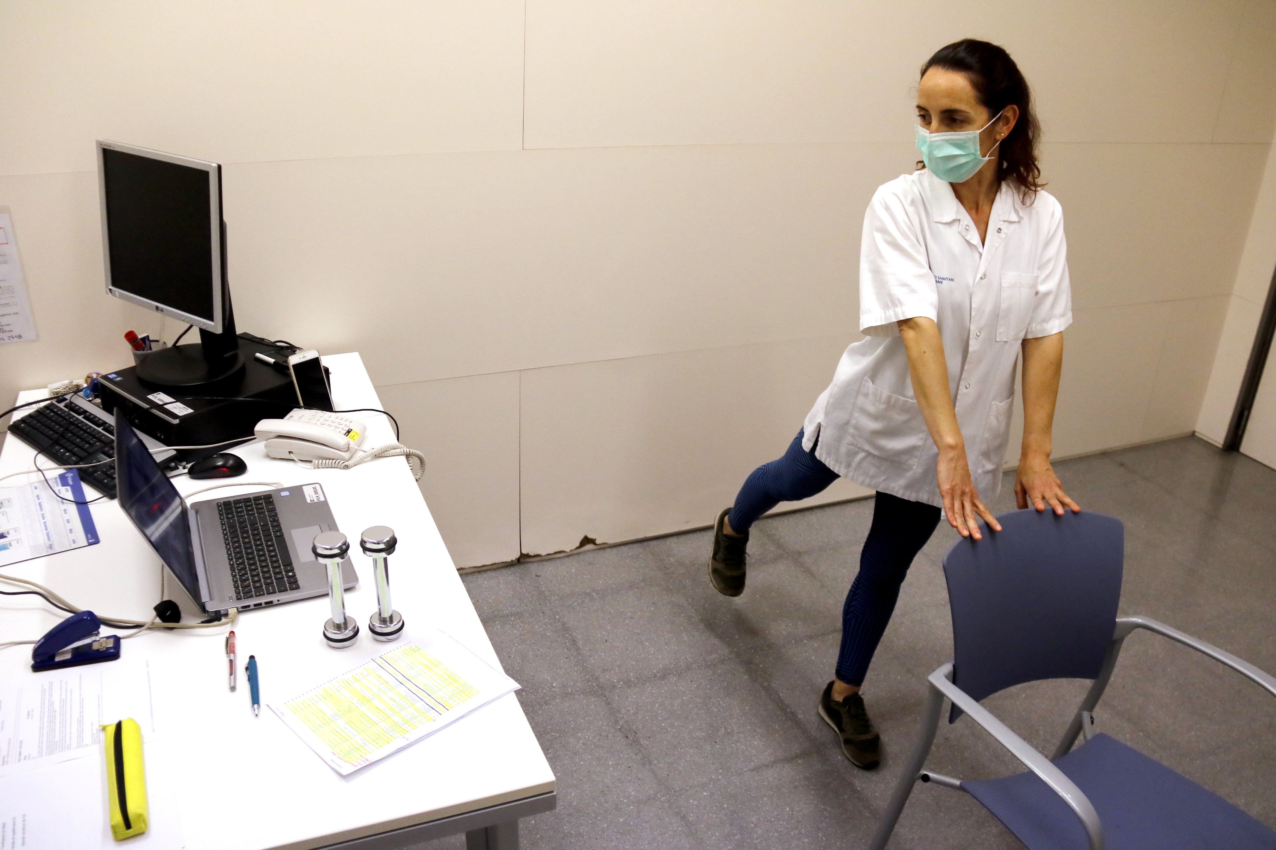 Una fisioterapeuta de l'Hospital de Mataró conversa amb els pacients postcovid durant una sessió de rehabilitació telemàtica. Foto: ACN