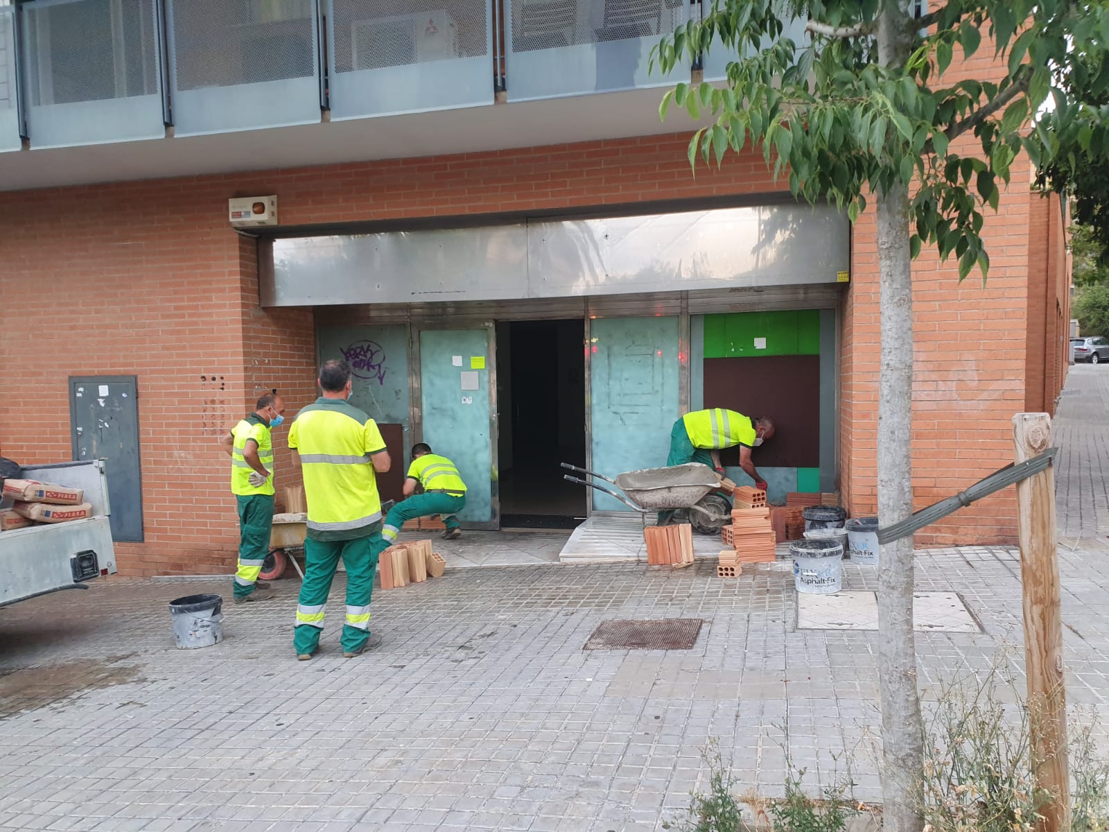 La brigada municipal, tapiant el acceso al local ocupado a la Vía Europa de Mataró. Foto: Cedida