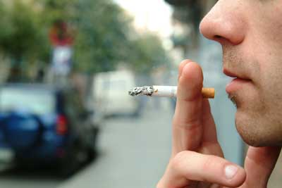Un trabajador se fuma un cigarrillo en la calle Un trabajador se fuma un cigarrillo en la calle
