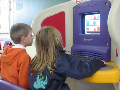 Dos alumnos de P5 usando el ordenador del aula.